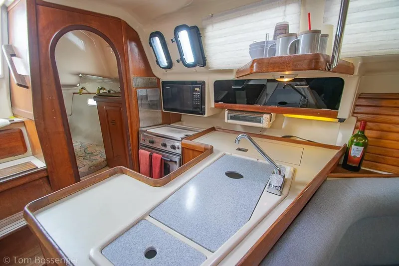 Slide: The Image of Interior of a 1995 Hunter 336 sailboat galley with wood accents and modern amenities. - 10