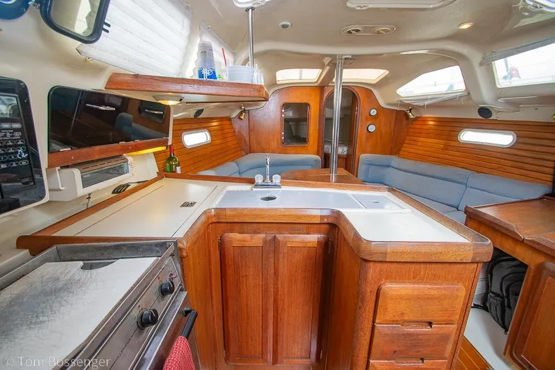 Slide: The Image of Interior of a 1995 Hunter 336 sailboat with wooden cabinetry and seating. - 11