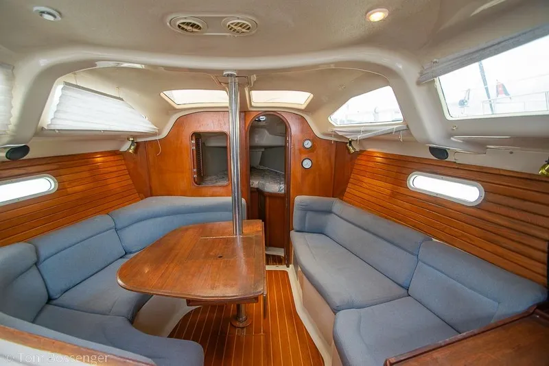 Slide: The Image of Interior of a 1995 Hunter 336 sailboat with wooden paneling and blue seating. - 12