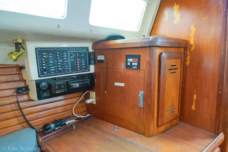 Slide: The Image of Interior of a 1995 Hunter 336 sailboat showing control panel and wooden cabinetry. - 13