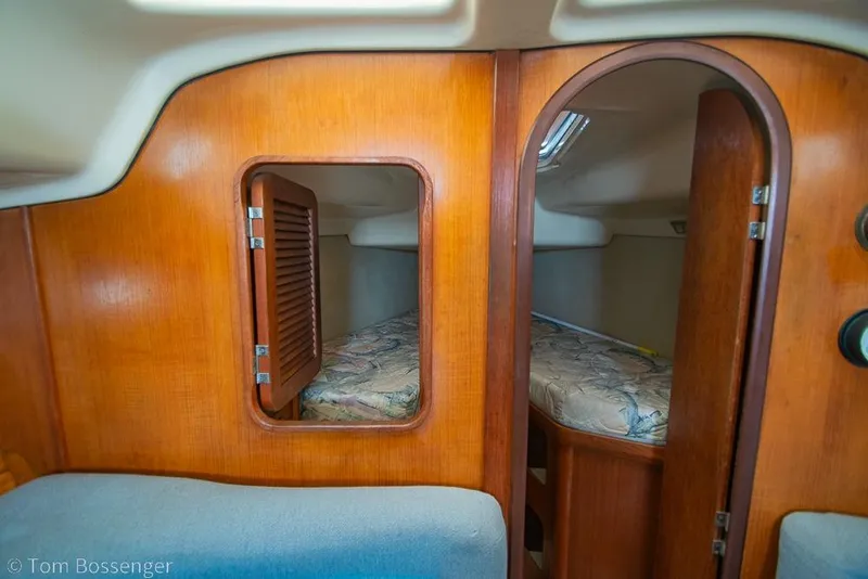 Slide: The Image of Interior cabin of a 1995 Hunter 336 sailboat with wooden paneling and cozy sleeping area. - 15
