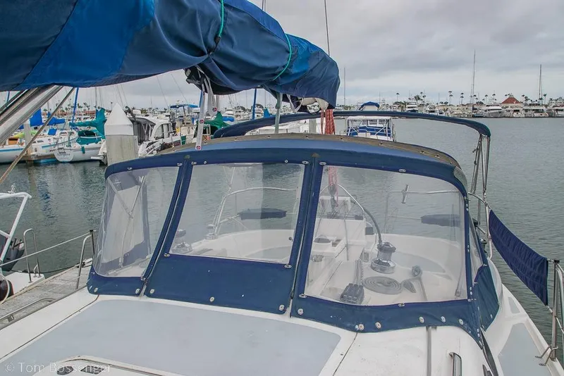 Slide: The Image of 1995 Hunter 336 sailboat docked in marina with blue canopy and clear windshield. - 32