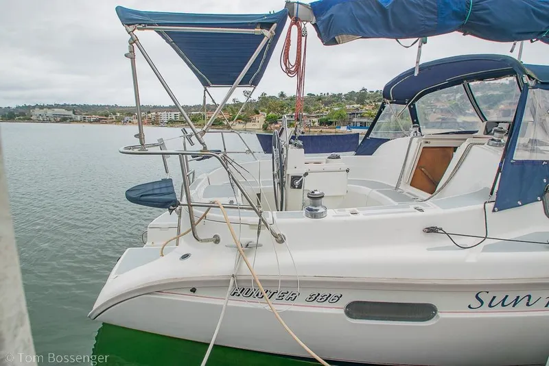 Slide: The Image of 1995 Hunter 336 sailboat docked, featuring blue canopy and spacious cockpit. - 4