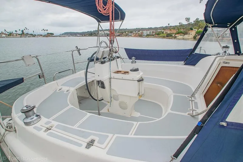 Slide: The Image of Cockpit of a 1995 Hunter 336 sailboat with blue canopy and scenic harbor view. - 5