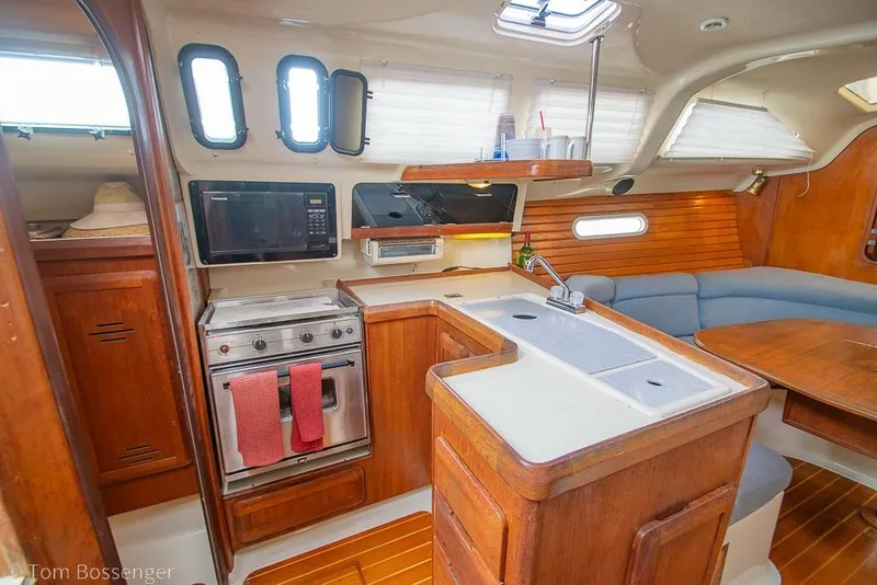 Slide: The Image of Interior of a 1995 Hunter 336 sailboat featuring a cozy kitchen and dining area. - 8