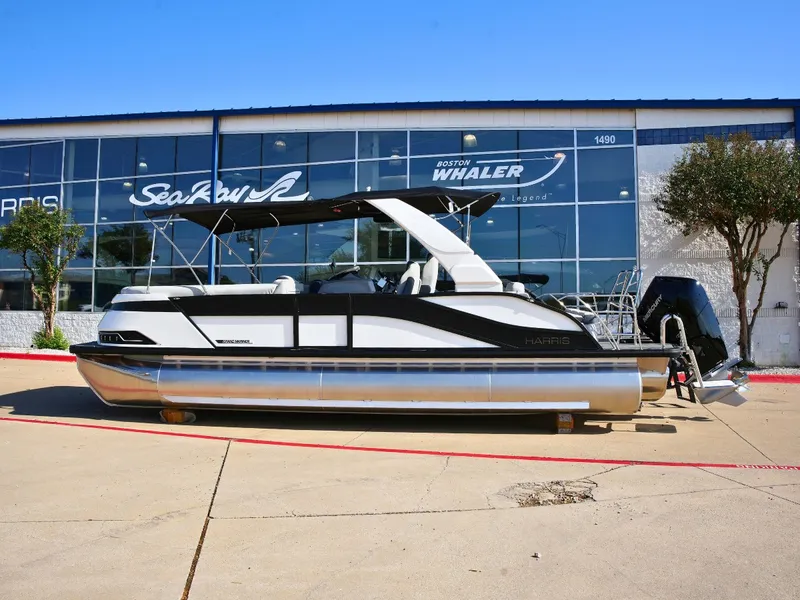 Slide: The Image of A 2027 Harris Grand Mariner 250 pontoon boat is parked in front of a building. - 0