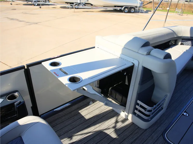 Slide: The Image of The image shows the rear of a 2027 Harris Grand Mariner 250 with a fold-out table and cup holders. - 13