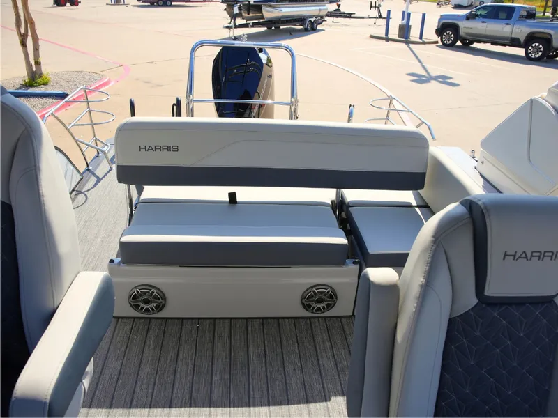 Slide: The Image of The image shows the deck of a 2027 Harris Grand Mariner 250. It features cushioned seating and speakers. - 26