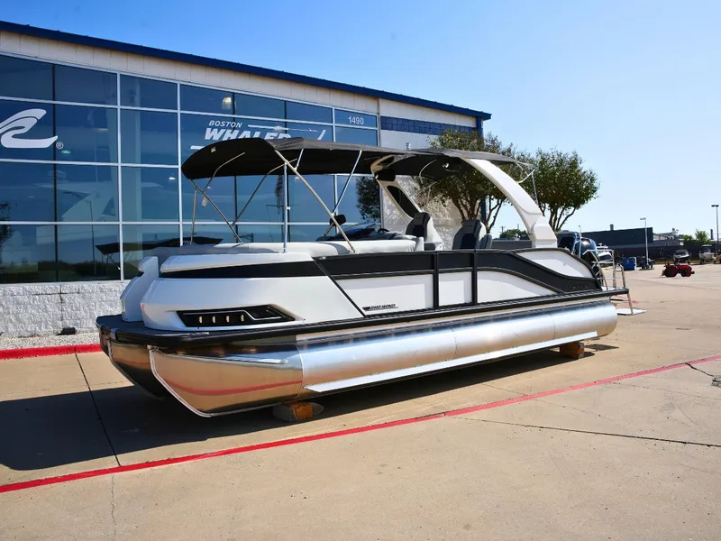 Slide: The Image of A modern pontoon boat with sleek design is parked in front of a building. - 1