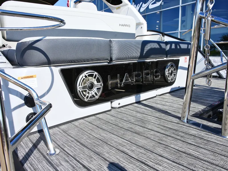 Slide: The Image of The image shows the deck of a 2027 Harris Grand Mariner 250 with gray cushions and speakers. - 6