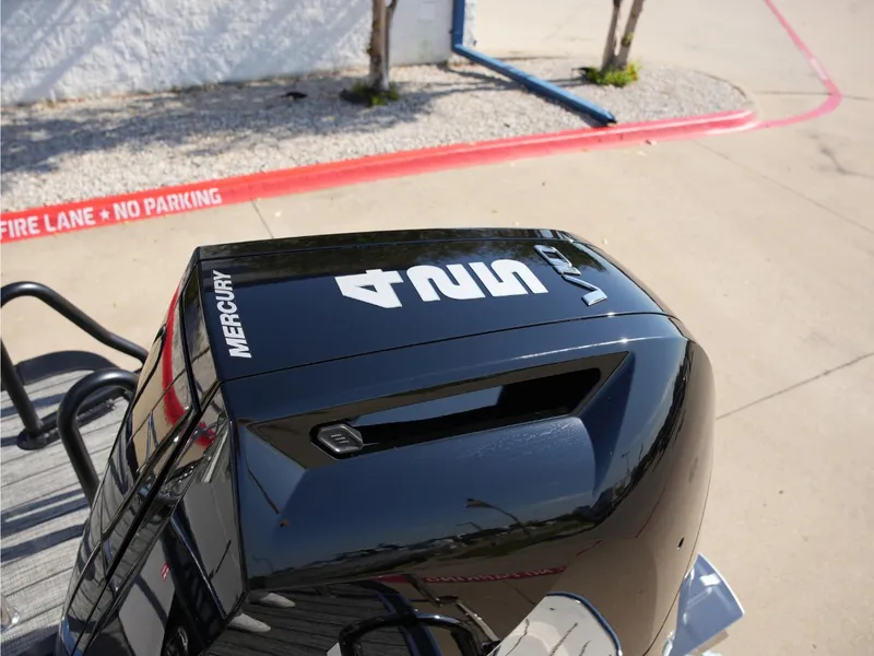 Slide: The Image of A Mercury outboard motor is mounted on a boat parked in a lot. - 37