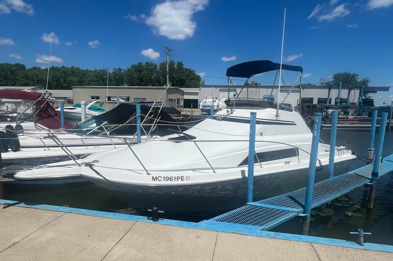 The Image of 1988 Seafox 29 Flybridge boat docked at marina under clear blue sky. - 0