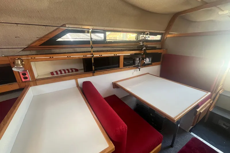 Slide: The Image of Interior of 1988 Seafox 29 Flybridge with red seating and wooden accents. - 17