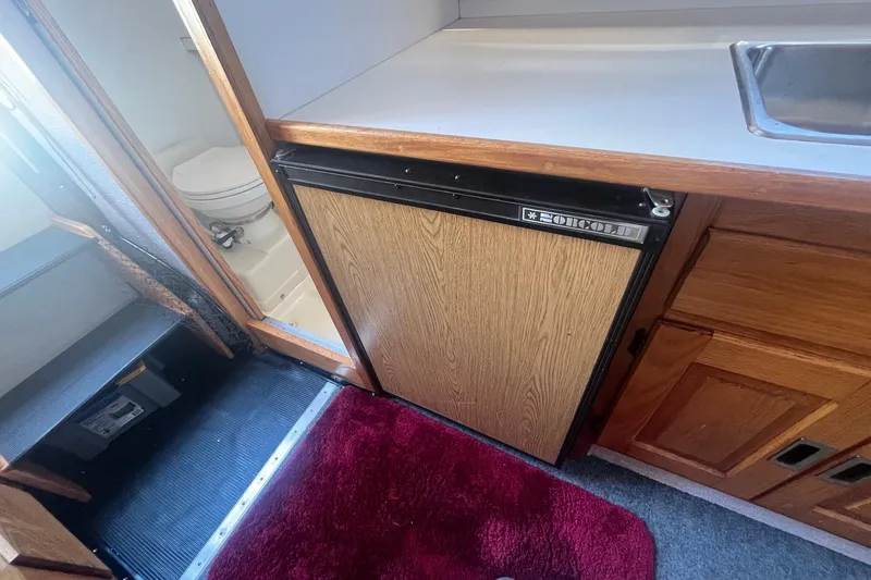 Slide: The Image of Interior of 1988 Seafox 29 Flybridge with fridge, sink, and bathroom. - 18