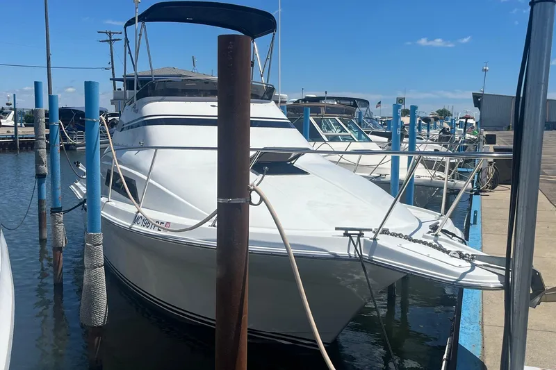 Slide: The Image of 1988 Seafox 29 Flybridge boat docked at marina under clear blue sky. - 2