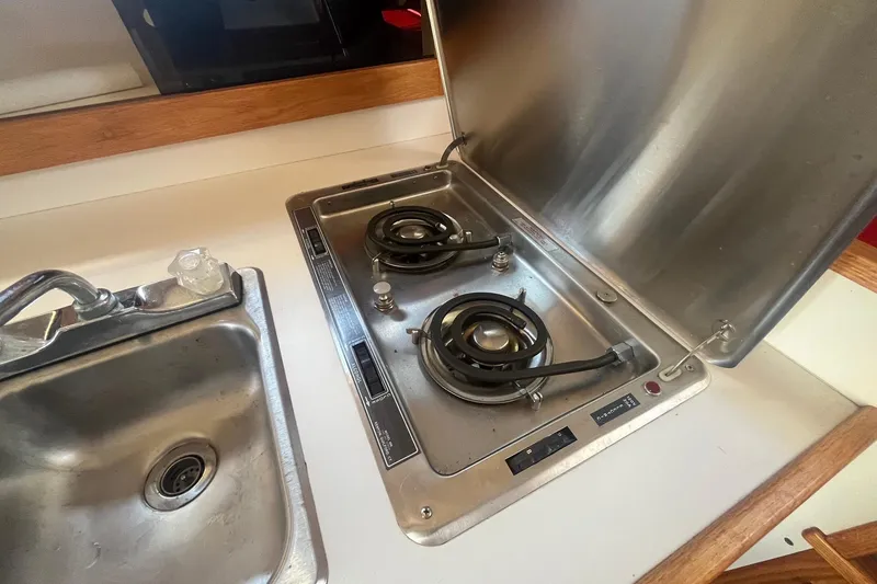 Slide: The Image of 1988 Seafox 29 Flybridge kitchen with stainless steel sink and dual-burner stove. - 20