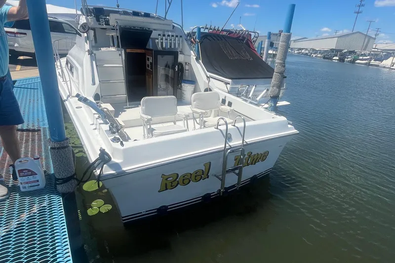 Slide: The Image of 1988 Seafox 29 Flybridge boat named "Reel Time" docked at a marina. - 4