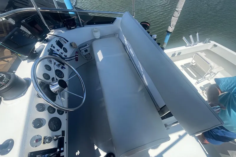 Slide: The Image of 1988 Seafox 29 Flybridge helm with steering wheel, gauges, and seating, overlooking water. - 7