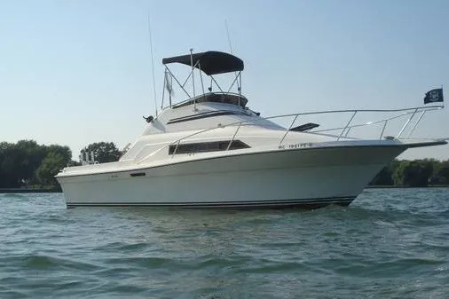 The Image of 1988 Rare Seafox 29 Flybridge boat on calm water, clear sky background. - 0