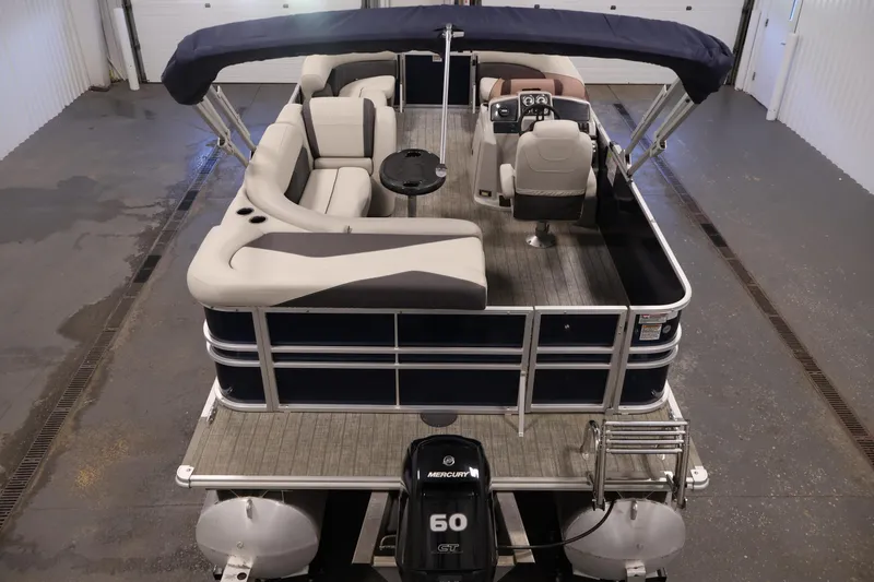 Slide: The Image of 2022 Sylvan 8520 Mirage pontoon boat with seating and canopy in a garage. - 10