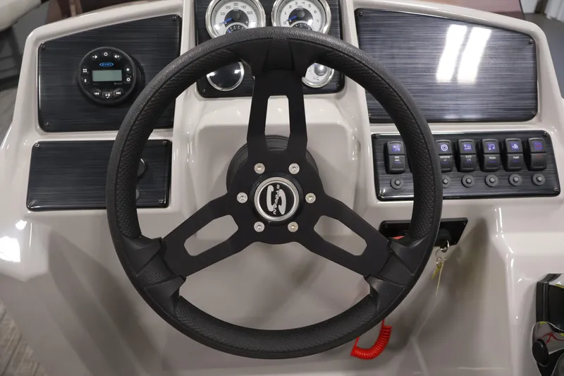 Slide: The Image of Steering wheel and dashboard of 2022 Sylvan 8520 Mirage boat, featuring controls and gauges. - 18