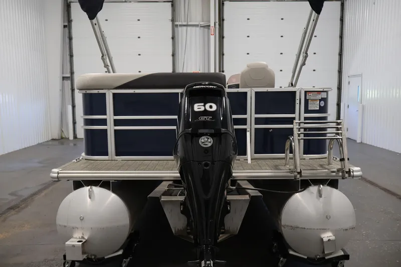 Slide: The Image of 2022 Sylvan 8520 Mirage pontoon boat with Mercury 60 HP engine in a garage. - 6