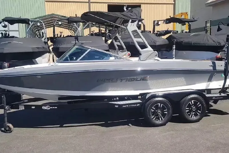 The Image of 2018 Nautique Ski Nautique 200 Open Bow boat on trailer, parked outdoors. - 0