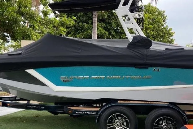 The Image of 2020 Nautique Super Air Nautique GS20 boat with cover on trailer, side view. - 0