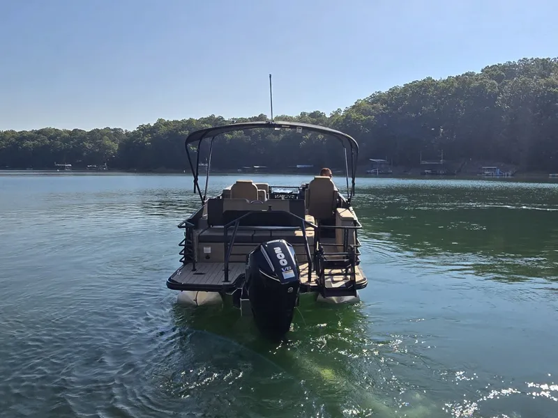 Slide: The Image of A 2027 Sylvan MIRAGE X3 ULZ pontoon boat on a calm lake with wooded shores. - 33
