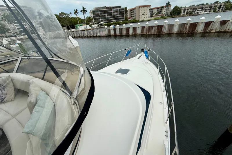Slide: The Image of 2000 Silverton 351 Sedan yacht docked in a marina, featuring spacious deck and seating area. - 10