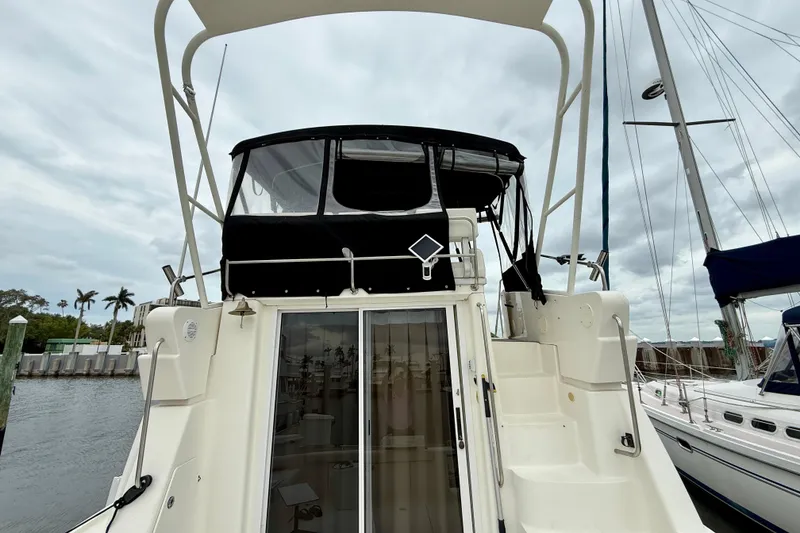Slide: The Image of 2000 Silverton 351 Sedan yacht docked, featuring a spacious upper deck and sleek design. - 11