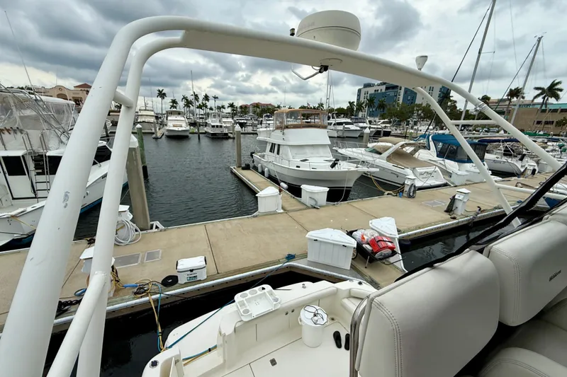 Slide: The Image of 2000 Silverton 351 Sedan at marina, surrounded by boats under cloudy skies. - 12
