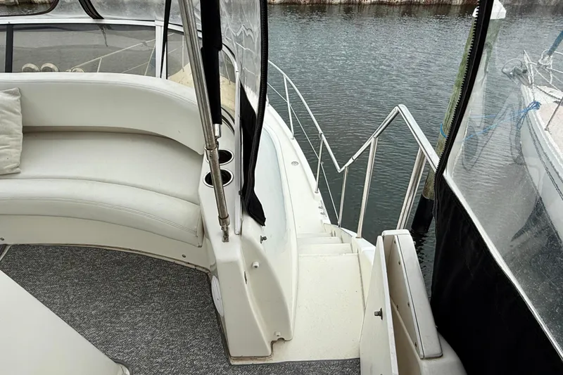 Slide: The Image of 2000 Silverton 351 Sedan boat interior with white seating and water view. - 16