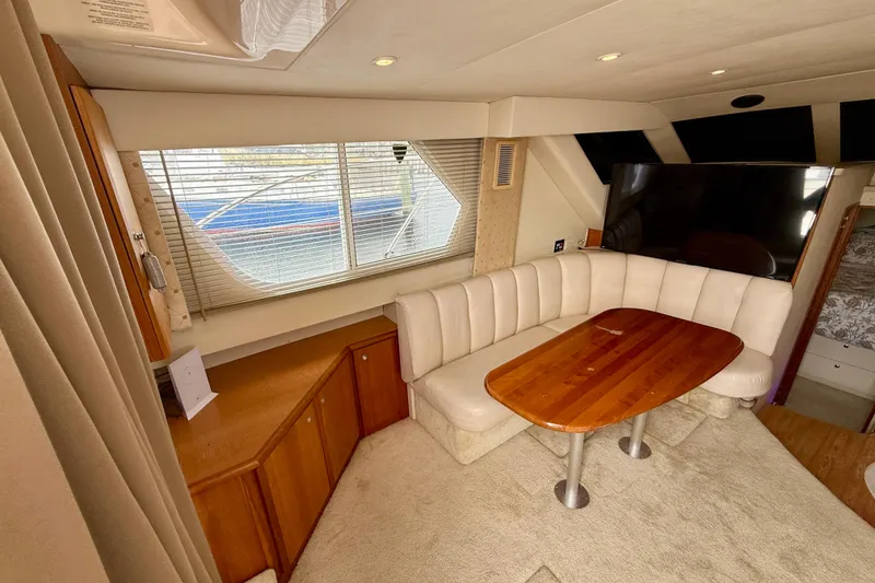 Slide: The Image of Interior of 2000 Silverton 351 Sedan yacht with cozy seating and wooden table. - 32