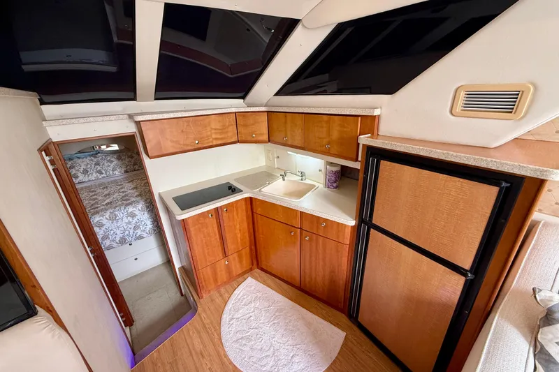 Slide: The Image of Interior of 2000 Silverton 351 Sedan yacht with kitchenette and cozy sleeping area. - 34