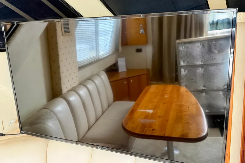 Slide: The Image of Interior of 2000 Silverton 351 Sedan with wooden table and cushioned seating. - 38