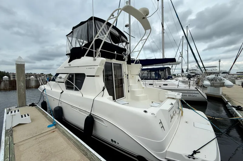 Slide: The Image of 2000 Silverton 351 Sedan yacht docked at marina under cloudy sky. - 4