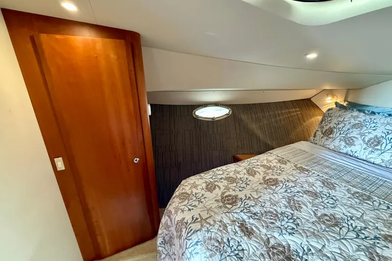 Slide: The Image of Cozy bedroom interior of 2000 Silverton 351 Sedan yacht with wood door and patterned bedding. - 43