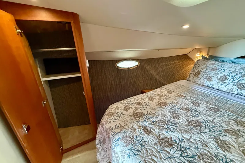 Slide: The Image of Interior of 2000 Silverton 351 Sedan with cozy bed and open wooden closet. - 44