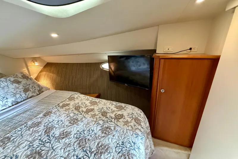 Slide: The Image of Cozy bedroom interior of 2000 Silverton 351 Sedan with floral bedding and wall-mounted TV. - 45