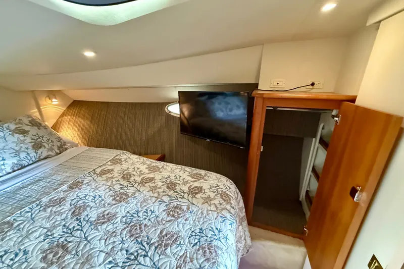 Slide: The Image of Interior of 2000 Silverton 351 Sedan yacht bedroom with TV and floral bedding. - 46