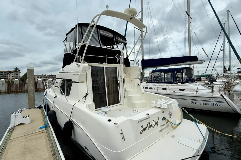 Slide: The Image of 2000 Silverton 351 Sedan yacht docked at marina, overcast sky. - 5