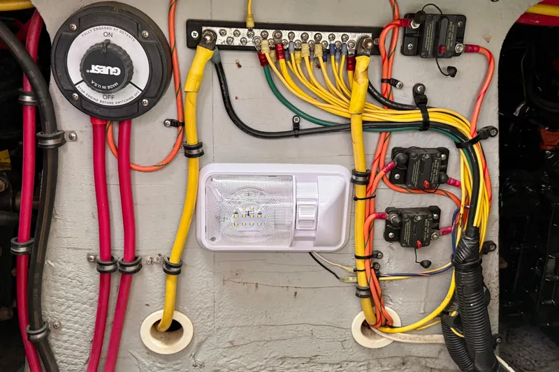 Slide: The Image of Electrical wiring panel in a 2000 Silverton 351 Sedan boat, featuring various colored cables and switches. - 50