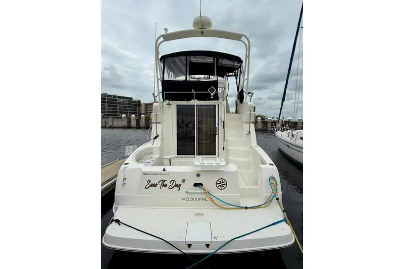 Slide: The Image of 2000 Silverton 351 Sedan yacht docked, rear view with overcast sky. - 7