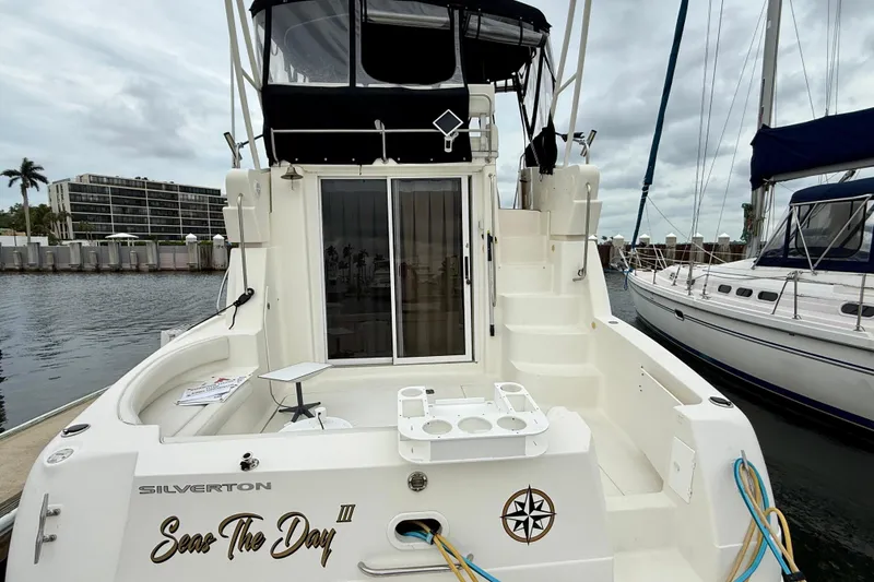 Slide: The Image of 2000 Silverton 351 Sedan yacht docked, featuring spacious deck and elegant design. - 8