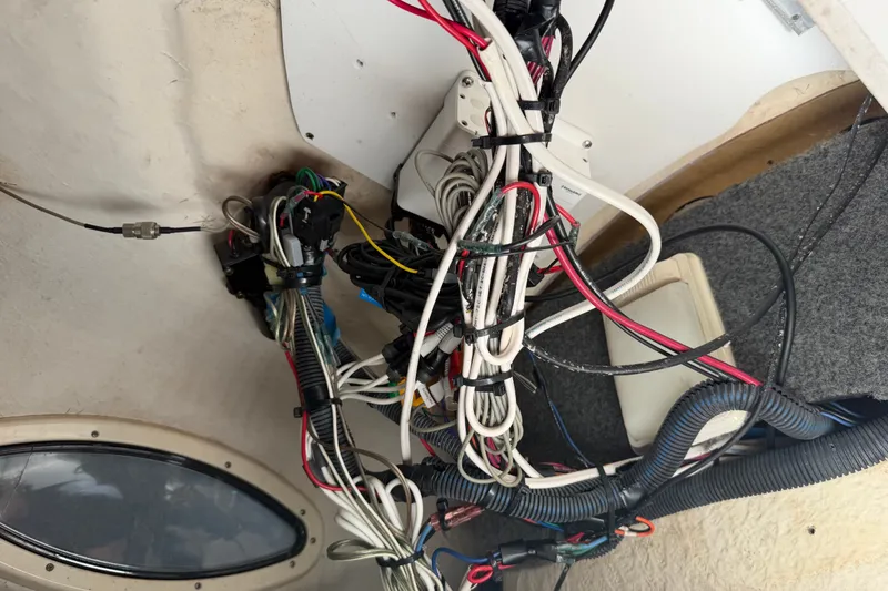 Slide: The Image of Tangled wiring inside a 2006 Sea Ray 240 Sundeck boat, showcasing electrical components. - 45
