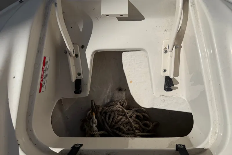 Slide: The Image of Storage compartment of a 2006 Sea Ray 240 Sundeck with coiled rope inside. - 57