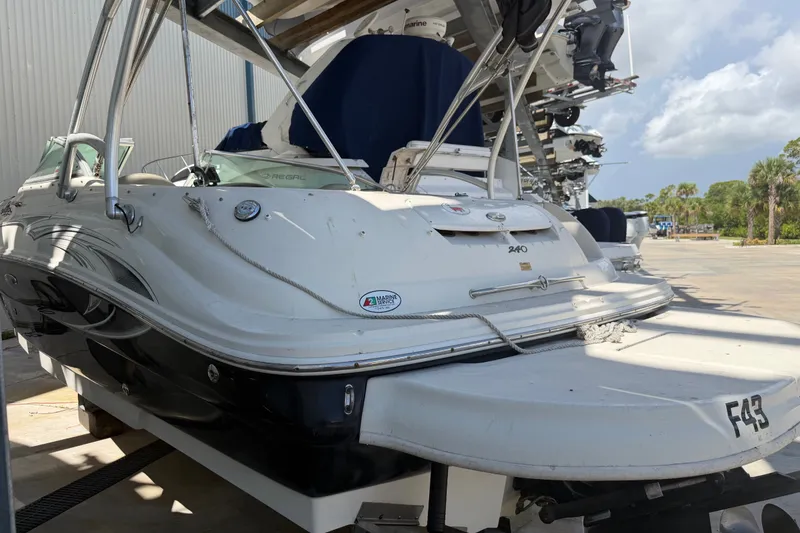 Slide: The Image of 2006 Sea Ray 240 Sundeck boat in storage, featuring sleek design and white exterior. - 5