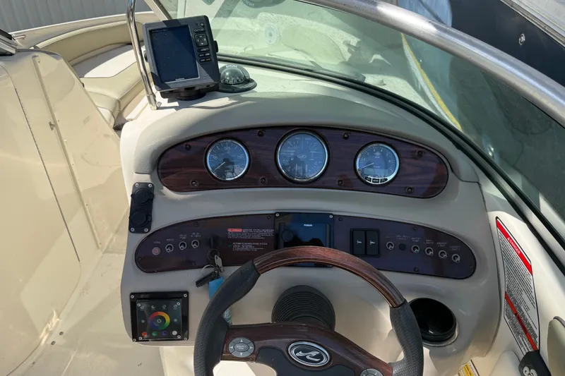 Slide: The Image of 2006 Sea Ray 240 Sundeck dashboard with gauges and navigation equipment. - 22