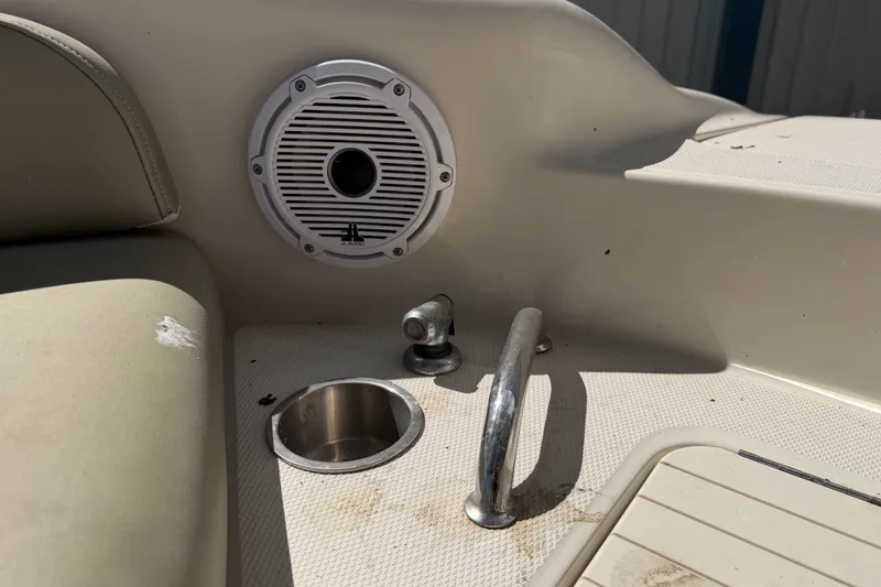 Slide: The Image of 2006 Sea Ray 240 Sundeck interior with speaker, cup holder, and railing. - 54